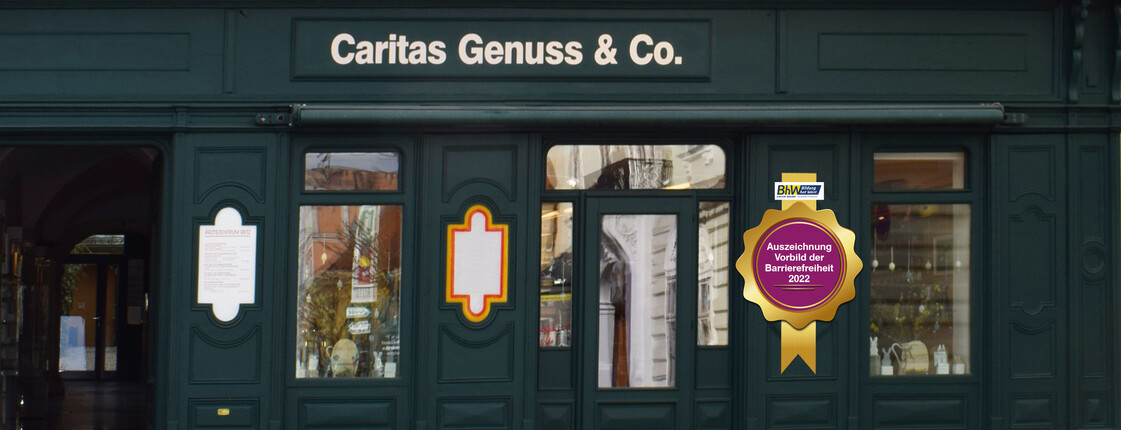 Grüne Außenfassade aus Holz, des Shops Caritas Genuss & Co. 