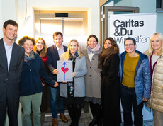 CEO Louis Kahane mit Mitarbeiter*innen der Bank Gutmann AG und Caritas-Mitarbeiter*innen vor dem neuen Lift. © Stefanie Steindl