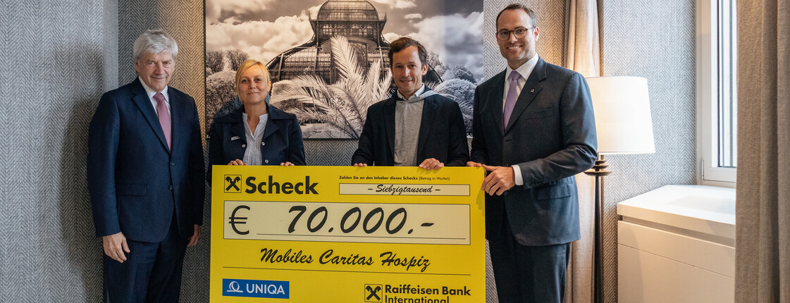 Raiffeisen Bank International Vorstandsvorsitzender Johann Strobl und UNIQA Vorstandsmitglied René Knapp übergeben den Spendenscheck an Christina Heger (Caritas Wien) und Klaus Schwertner, Caritasdirektor der Erzdiözese Wien