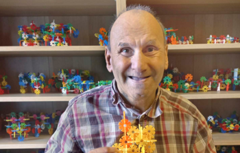 Künstler hält ein gebasteltes Kunstwerk in den Händen im Atelier der Caritas-Kunstgruppe im Weinviertel.