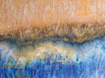 Abstraktes Bild, überwiegend in den Farben gelb und blau gehalten, dass an Wasser und Sand am Meer erinnert.