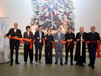 Eine Personengruppe durchschneidet ein rotes Band.