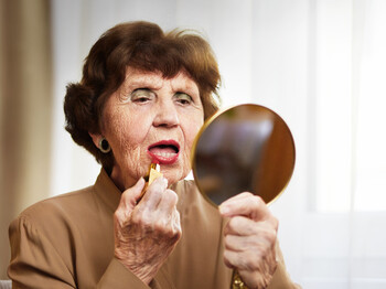 Seniorin beim Schminken