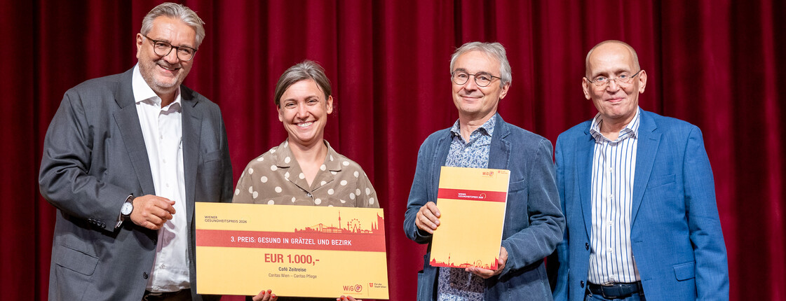 Vier Personen stehen auf einer Bühne und erhalten einen Preis.