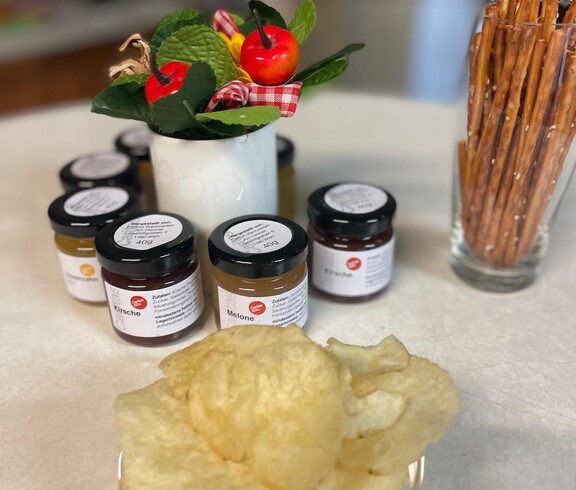 Marmeladen und Chips stehen auf einem Tisch.
