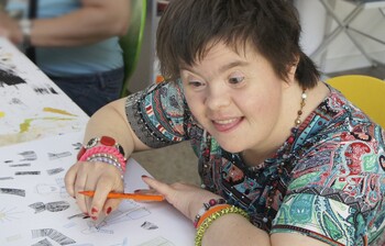 Künstlerin malt mit Stift einfarbige Bilder im Atelier der Caritas-Kunstgruppe im Weinviertel.