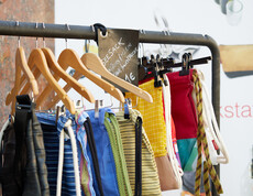 Bunte Upcycling-Turnbeutel an Kleiderstange beim Projekt reStart der Caritas, Preisschild mit 1 €