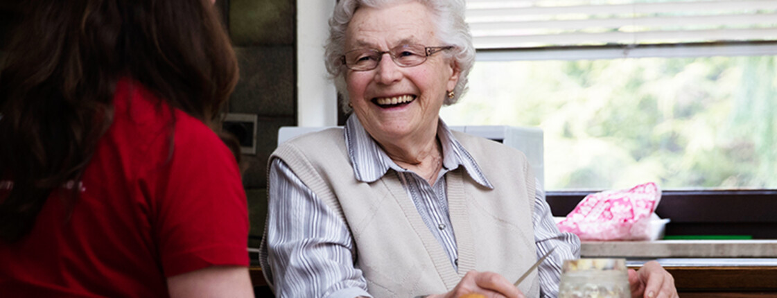 Seniorin am Küchentisch