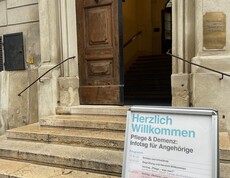 Herzlich Willkommen Schild steht vor einem Eingang
