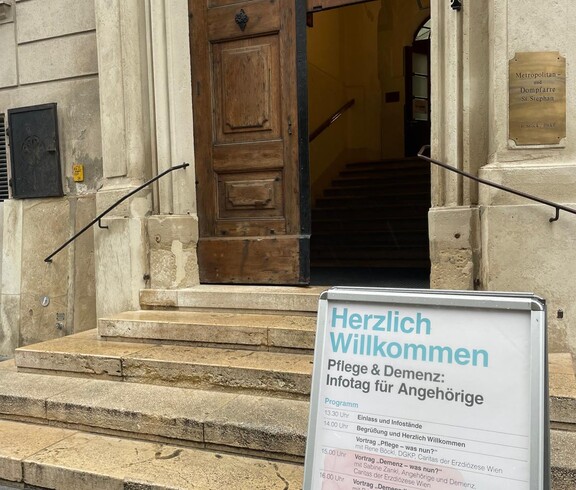 Herzlich Willkommen Schild steht vor einem Eingang