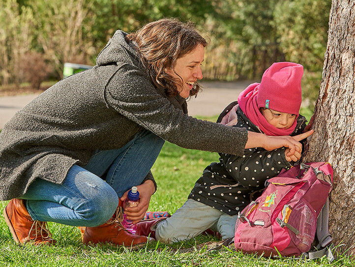 eine Mutter mit zwei Kindern spricht mit einer Frau