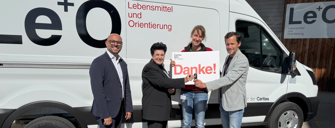 Vertreter*innen von Hoerbiger und der Caritas stehen vor dem Le+O Transporter