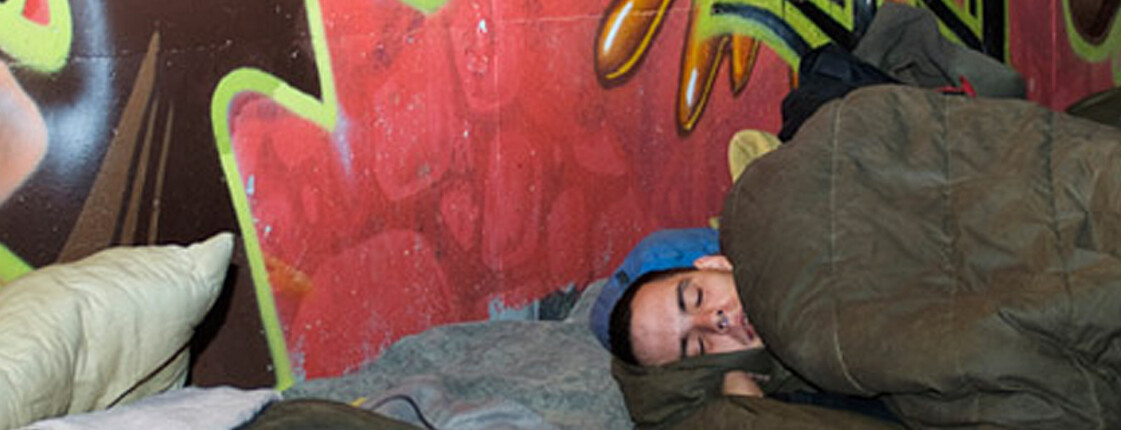 Ein Mann schläft in einem Schlafsack