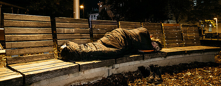 Obdachloser Mann in Einkaufsstraße